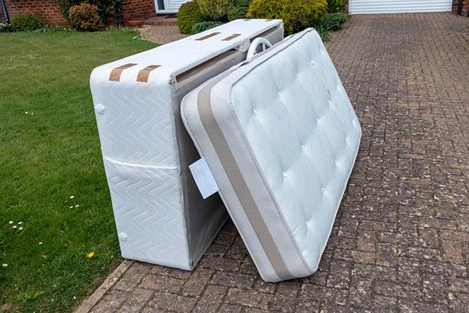 old mattresses being loaded onto a trailer for disposal